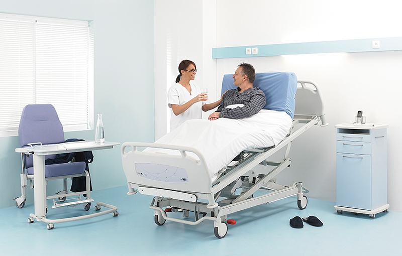 A person in a adapted bed is served by a nurse