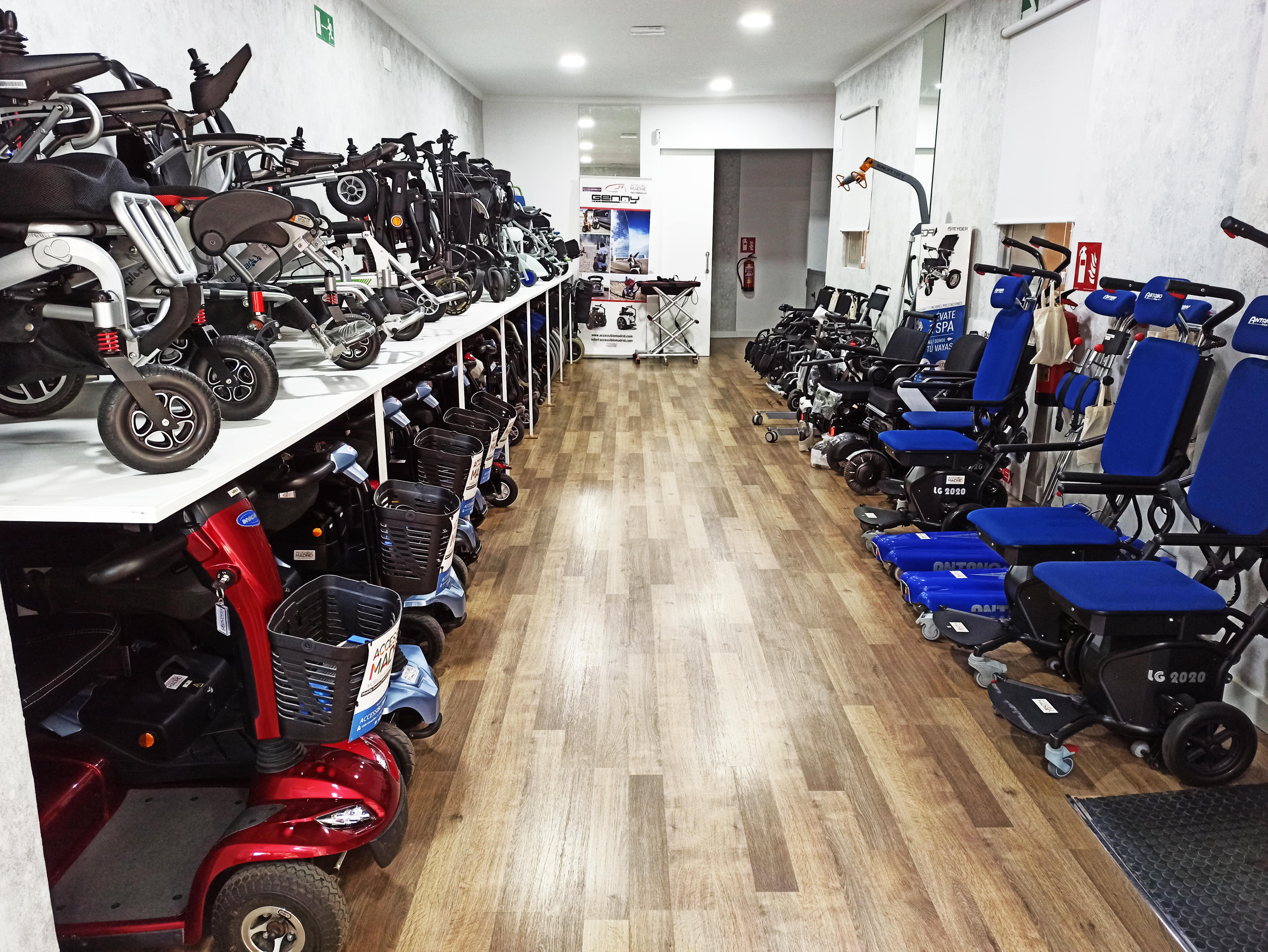 Pasillo largo con muestrario de sillas de ruedas y scooters de movilidad a los lados dentro de la tienda de Accessible Madrid