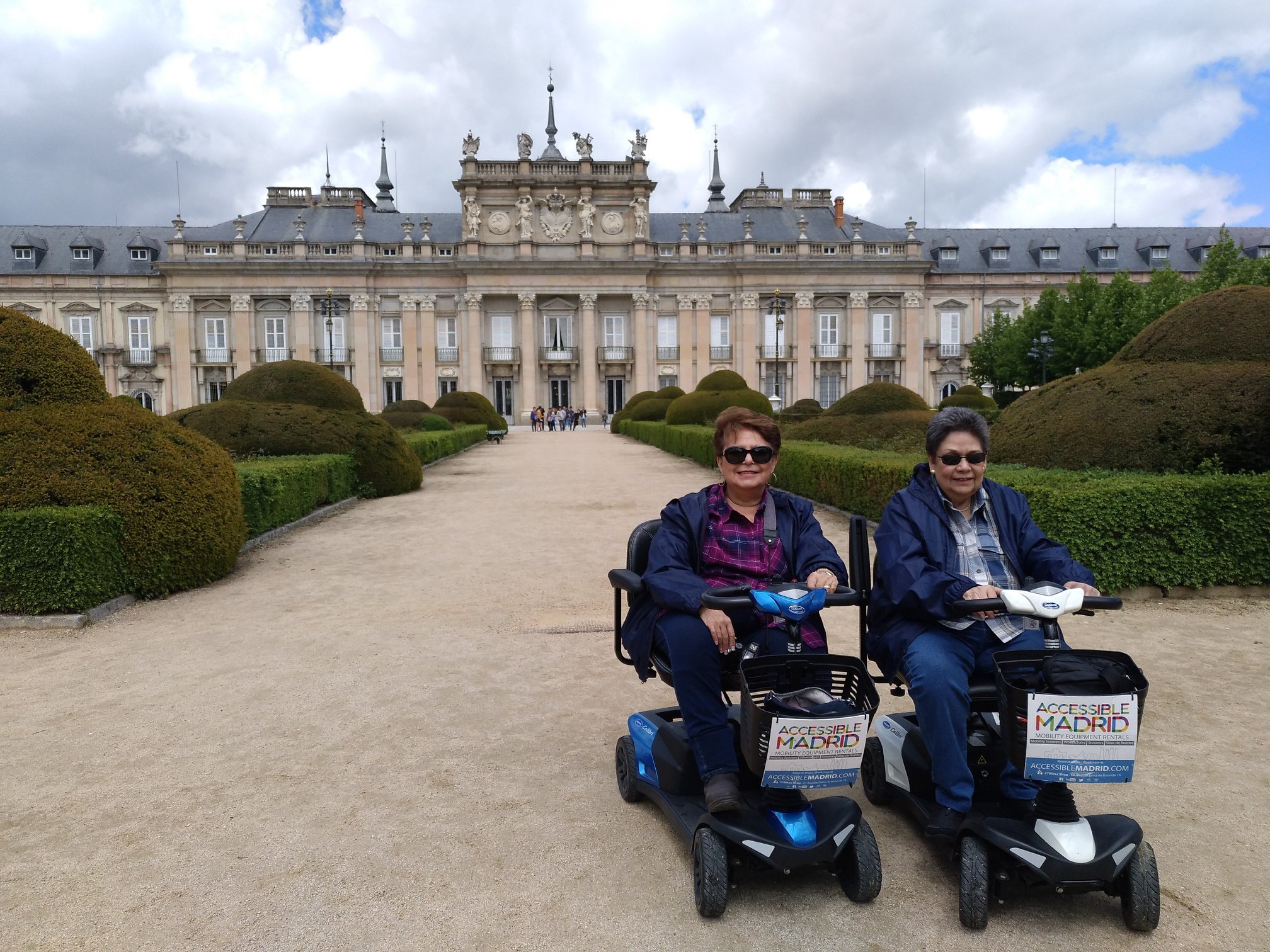 Dos personas en su scooter de movilidad posan en un tour de día. Palacio de la Granja
